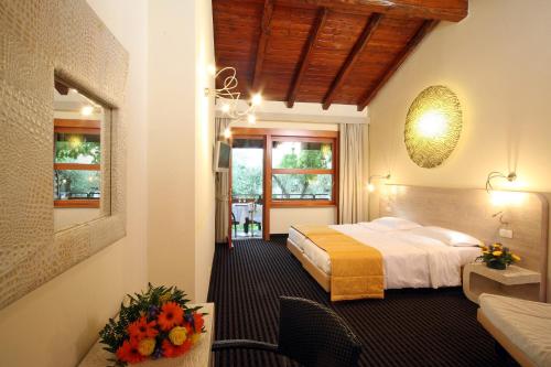 una habitación de hotel con una cama y flores. en Hotel Sailing Center, en Malcesine