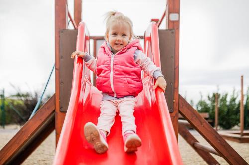 a little girl on a slide at a playground at Apartmán Ema Dolní Dunajovice in Dolní Dunajovice