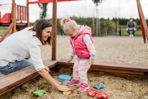 a woman and a little girl playing in a playground at Apartmán Ema Dolní Dunajovice in Dolní Dunajovice