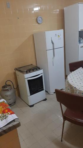 a kitchen with a stove and a refrigerator at Casa Jasmim arraial do cabo in Arraial do Cabo