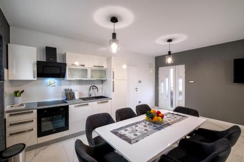 kuchnia i jadalnia ze stołem i krzesłami w obiekcie Luxury Villa Rebecca w mieście Brestovac