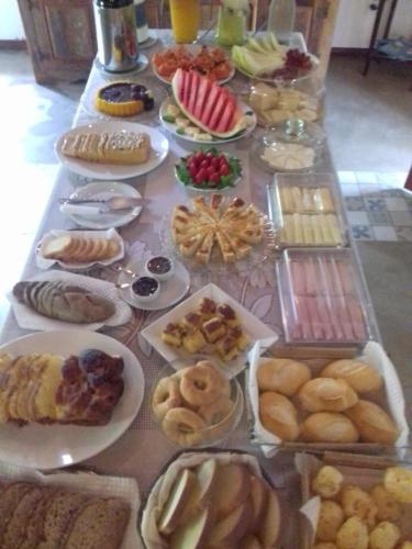 uma mesa cheia de diferentes tipos de comida em pratos em Chalés da Estrada Velha em Tiradentes