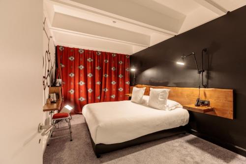 a bedroom with a bed and a red curtain at Totem, Friendly Hotel & Spa in Flaine