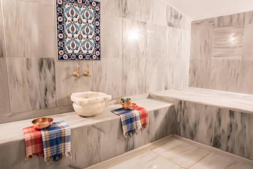 ein Badezimmer mit einem Waschbecken und einer Schale auf einem Regal in der Unterkunft Cocopalm Boutique Hotel Alaçatı in Alacati