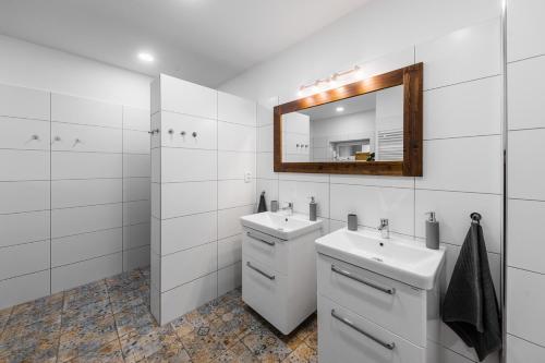 a white bathroom with a sink and a mirror at Chalupa Na Dědině in Dolní Dunajovice