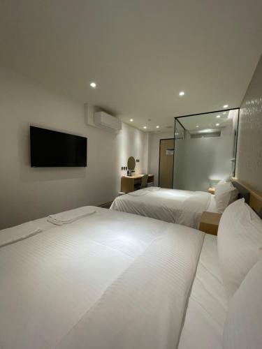 a hotel room with two beds and a flat screen tv at Michi Hotel - Zhongli in Zhongli