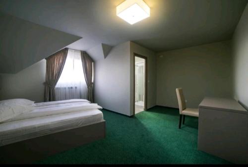 a bedroom with a bed and a window and a chair at CASA BUDISTEANU 2 in Focşani