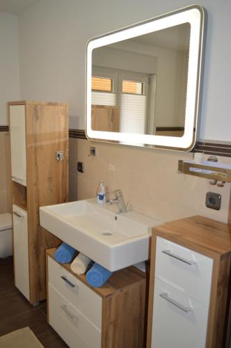 a bathroom with a sink and a mirror at FeWo Eifel in Frohngau
