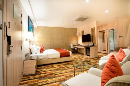 a hotel room with two beds and a desk at The Orchid Lonavala in Lonavala