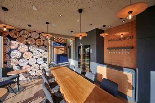 a restaurant with a long wooden table and chairs at Kucher's Landhotel in Darscheid
