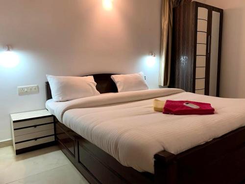 a bedroom with a large bed with a red bag on it at Sunshine in Old Goa
