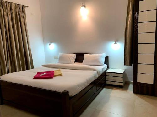 a bedroom with a bed with a red bag on it at Sunshine in Old Goa