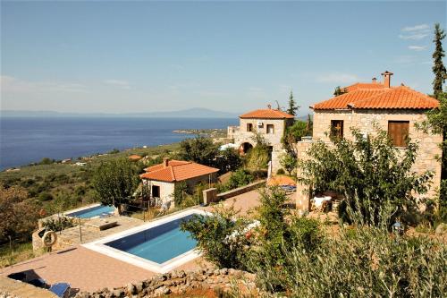 een huis op een heuvel met een zwembad bij ORATO VILLAGE in Pyrgos