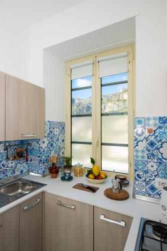 a kitchen with blue and white tiles on the wall at Casa Gilda Positano in Positano