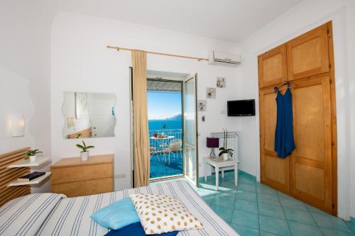 a bedroom with a bed and a door to a balcony at Casa Gilda Positano in Positano