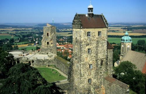 un vieux château avec deux tours sur une colline dans l'établissement Burghotel Stolpen, à Stolpen