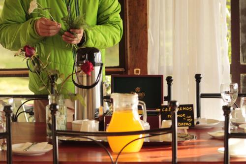 a person standing at a table with a jug of juice at Hospedaje Isla Magdalena in Punta Arenas
