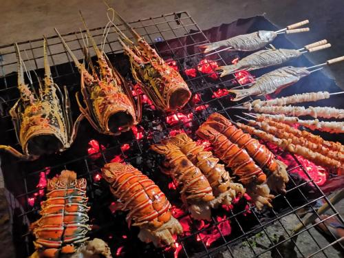 a bunch of food cooking on a grill at Thoddoo Beach Holiday in Thoddoo