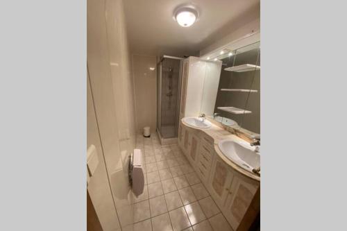 a bathroom with two sinks and a shower at Appartement rénové 4pers tout confort & garage in Cauterets