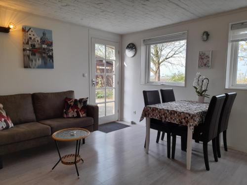 sala de estar con mesa y sofá en “In Oans Oefje” Parel in de polder!, en Lewedorp