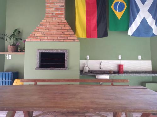 una habitación con una mesa y banderas en la pared en Vila Verde Suites en Florianópolis