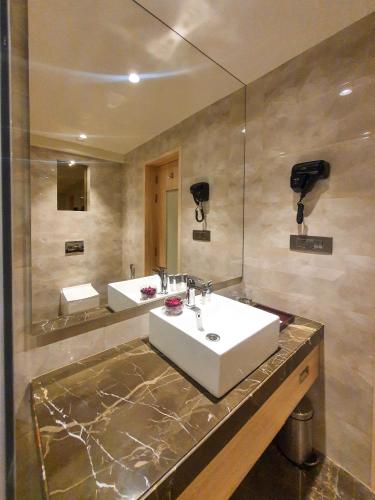 a bathroom with a white sink and a mirror at The Orchid Lonavala in Lonavala