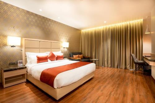 a hotel room with a bed and a desk at The Orchid Lonavala in Lonavala