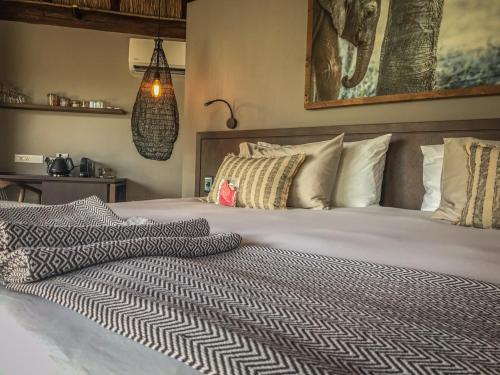 a bedroom with a large bed with white sheets and pillows at Laluka Safari Lodge - Welgevonden Game Reserve in Welgevonden Game Reserve