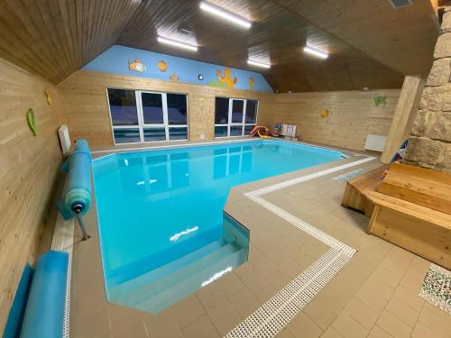 a large swimming pool in a room with at Hotel Peklo pro rodiny s dětmi in Josefŭv Dŭl