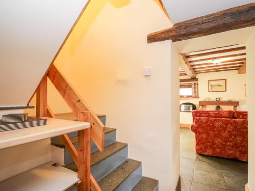 eine Treppe, die zu einem Wohnzimmer mit einem roten Sofa führt in der Unterkunft Stable End Cottage in Nether Wasdale