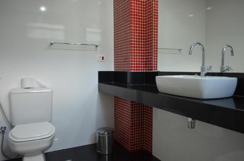 a bathroom with a white toilet and a sink at Hotel Diplomata Copacabana in Rio de Janeiro