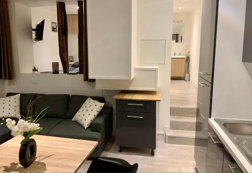 a living room with a couch and a kitchen at Appartement T2 centre-ville -003 in Rouen