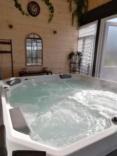 a large bath tub filled with water in a room at Le gîte du Moulin in Lagardelle-sur-Lèze