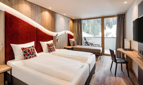 a hotel room with a bed and a desk at Sporthotel Obereggen in Obereggen