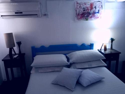 a bedroom with a blue bed with pillows on it at Porão reformado no centro de Floripa in Florianópolis