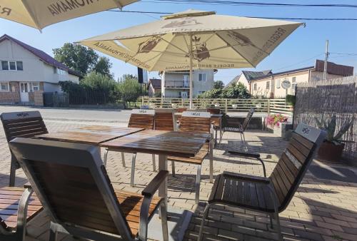 a wooden table and chairs with an umbrella at Pensiunea Prestige House in Curtea de Argeş