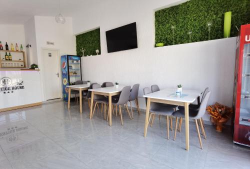 a dining room with tables and chairs and a tv at Pensiunea Prestige House in Curtea de Argeş