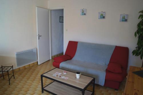 un salon avec un canapé rouge et une table basse dans l'établissement Lara 4 - T2 spacieux Parking - Près centre-port, île des Loisirs, plage Richelieu, au Cap d'Agde