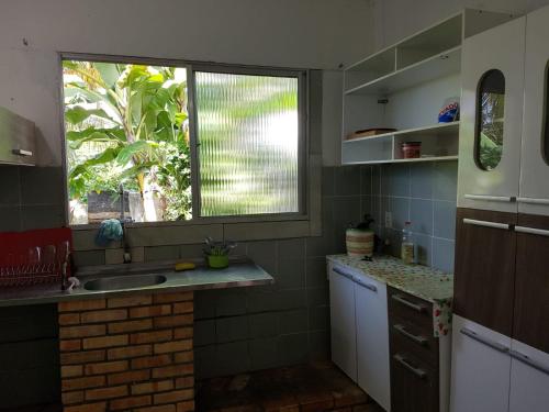 cocina con fregadero y ventana en CASA SOL de PIRANGI, en Pirangi do Sul