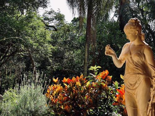 a statue of a woman in a garden with flowers at Villa Serena Bed & Breakfast in Embu