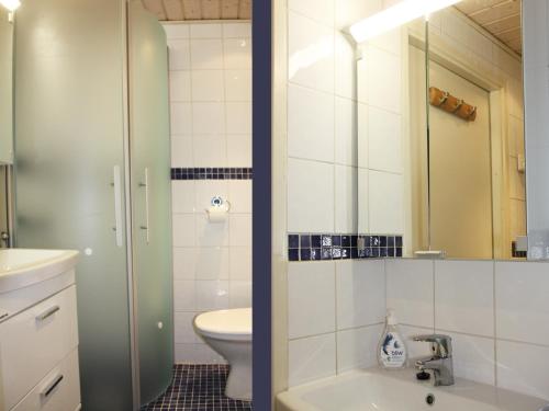 a bathroom with a sink and a toilet and a mirror at Jokikatu kaksio in Turku