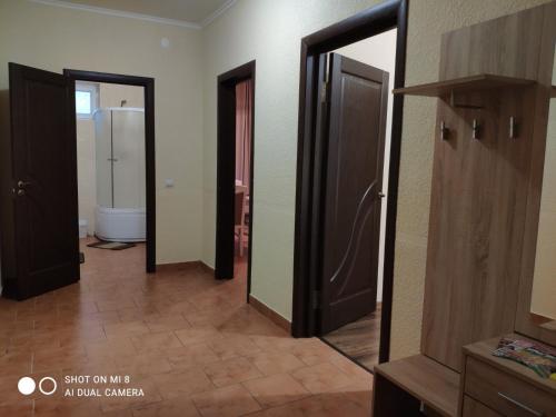 La salle de bains est pourvue de 3 portes ouvertes et d'un miroir. dans l'établissement Apartments Domovik "Uyut", à Moukatcheve