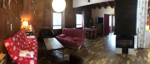 a living room with red couches and a fireplace at Boost Your Immo Chalet Vars 371 in Vars