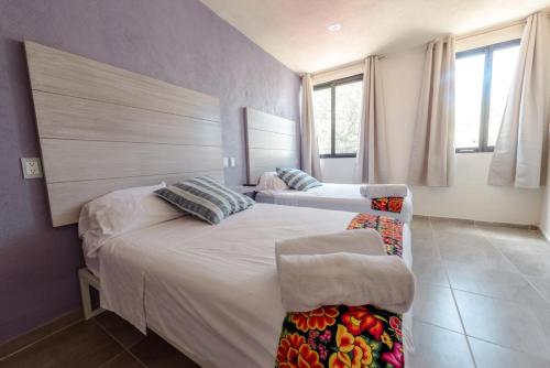 - une chambre avec 2 lits et une grande fenêtre dans l'établissement Hotel Hai Do, à Bernal