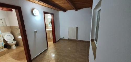 a bathroom with a toilet and a clock on the wall at Casa COLT DE RAI in Brezoi