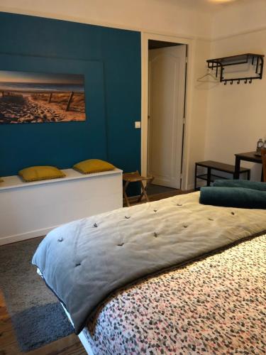a bedroom with two beds and a blue wall at Les Chênes in Bénesse-Maremne