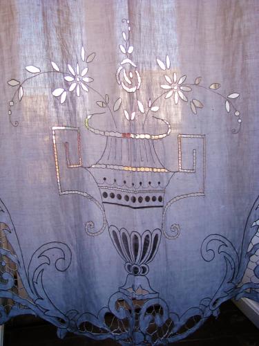 a curtain with a vase with flowers on it at B&B L'Orto Sul Tetto in Ragusa
