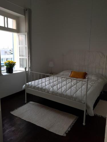 a white bed in a room with a window at Town Apartment with panoramic seaview in Paphos