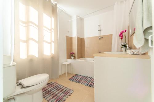 a bathroom with a toilet and a sink and a tub at Town Apartment with panoramic seaview in Paphos