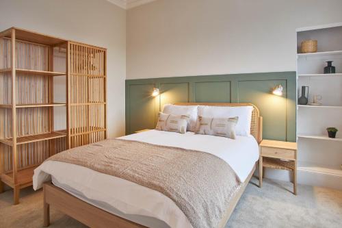 een slaapkamer met een groot bed met een groen hoofdeinde bij Host & Stay - Huntcliff View Apartment in Saltburn-by-the-Sea